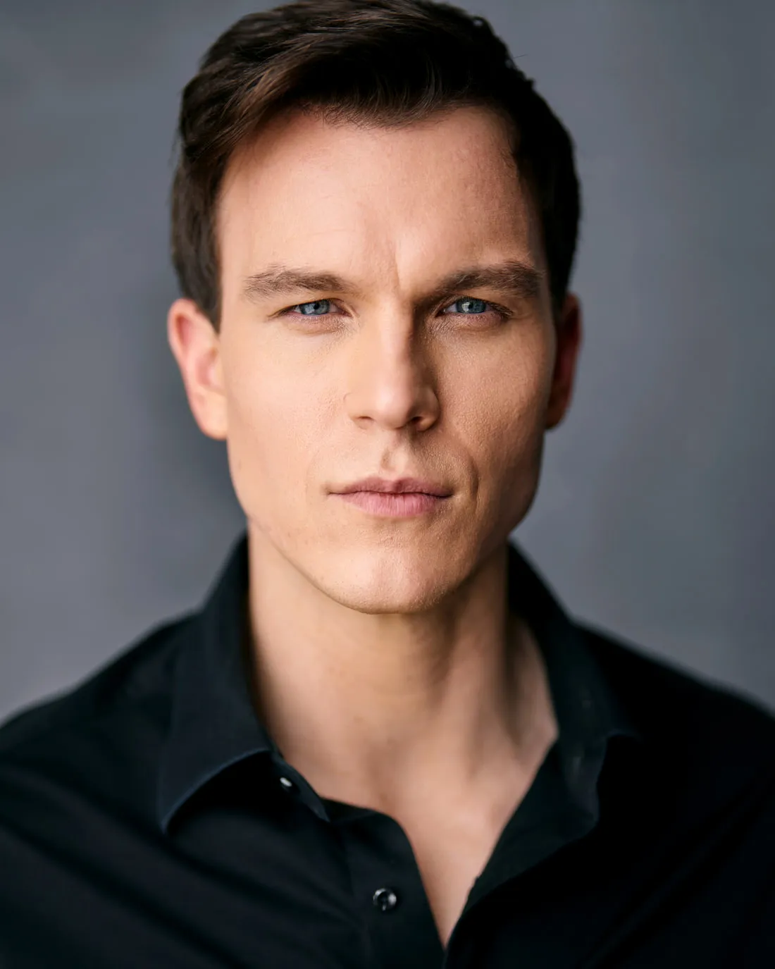 Steven Roderick Jurich in a black button shirt against a grey backdrop