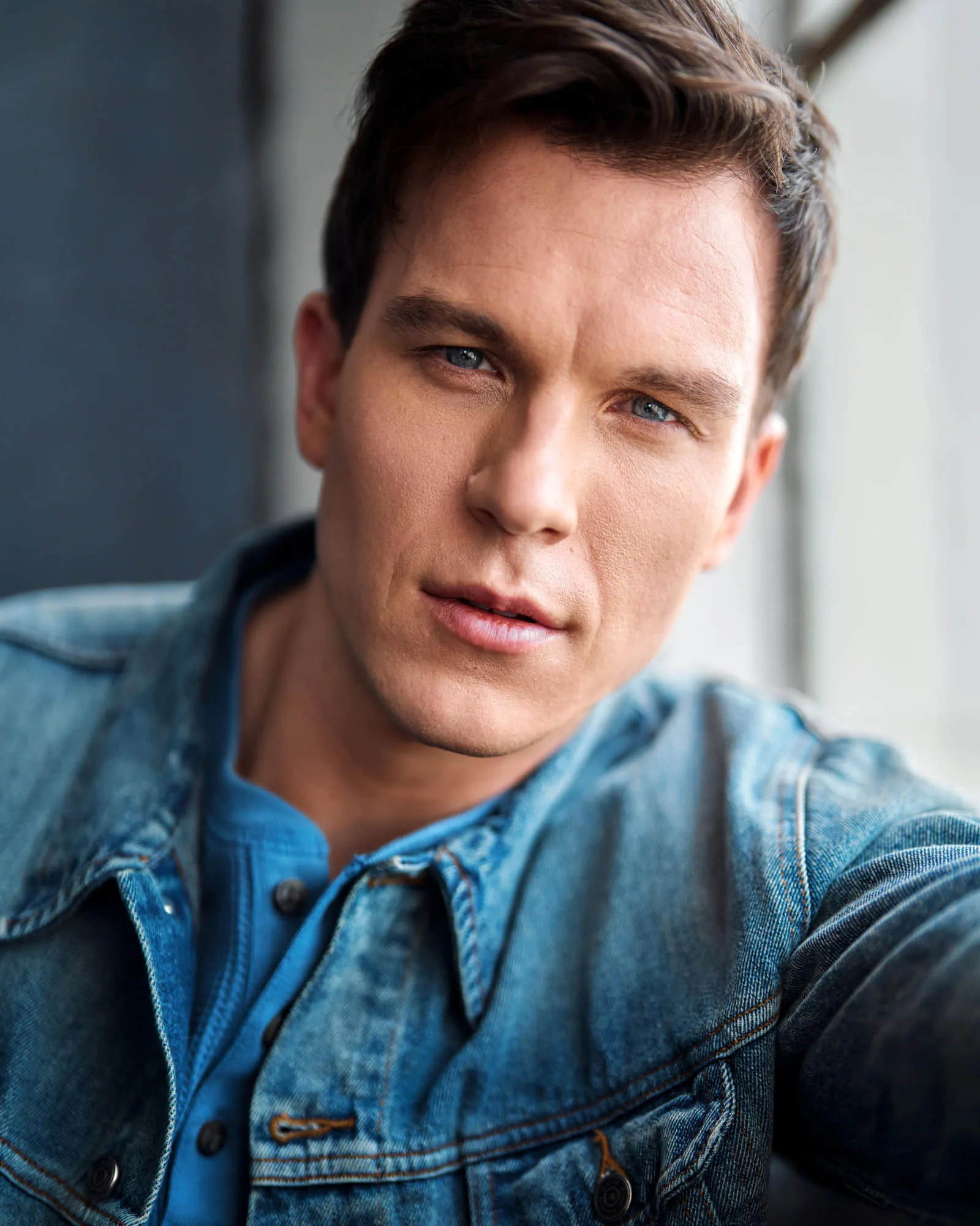 Steven Roderick Jurich in a denim jacket over a blue henley, seated and direct to camera