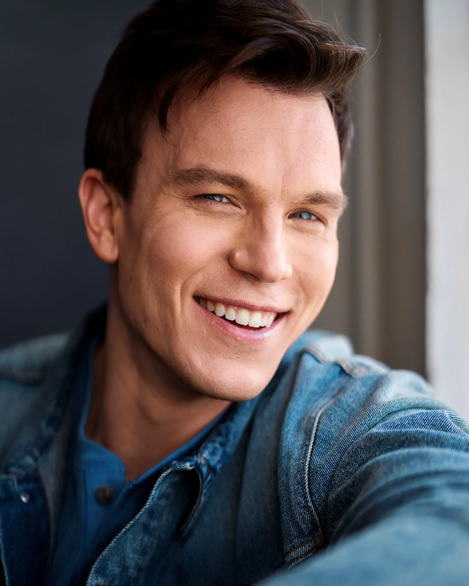 Steven Roderick Jurich laughing in a denim jacket, warm daylight